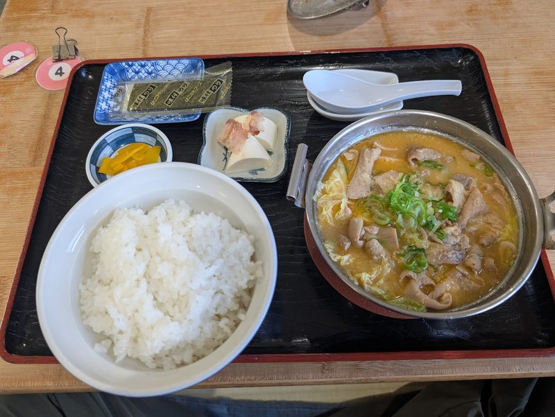 鍋のホルモン煮込みにご飯、漬物、小鉢がついた定食