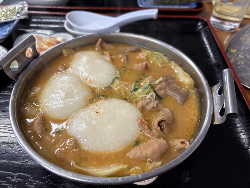 白いお餅を2個入れた、鍋のホルモン煮込み
